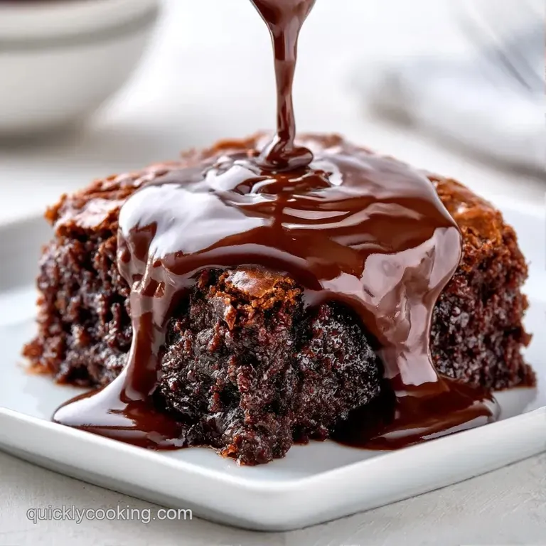 A square of rich dark chocolate cake dusted with powdered sugar on a slate plate with a swirl of salted caramel.